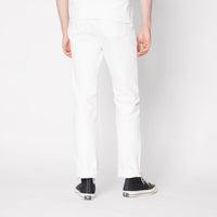 Person wearing white pants and black shoes on a plain background